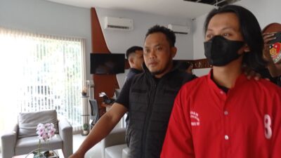 Tersangka RZ memakai baju tahanan warna merah, saat digiring petugas kepolisian menuju sel tahanan mapolrestabes surabaya (foto:samsul-harianradar.com).
