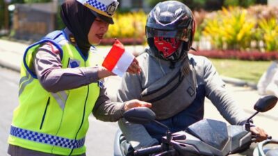 Puluhan aparat dari Satlantas Polrestabes Surabaya membagikan bendera merah putih di Seputar Jalan Polisi Istimewa Surabaya.