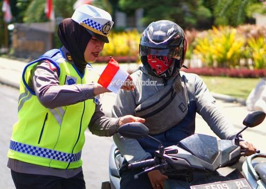 Puluhan aparat dari Satlantas Polrestabes Surabaya membagikan bendera merah putih di Seputar Jalan Polisi Istimewa Surabaya.