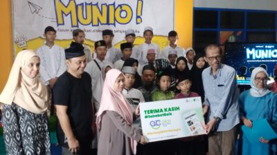 Keterangan foto : Ketua Dewan Pembina YPWJT, Dr Suprawoto saat menyerahkan santunan kepada puluhan anak Panti Asuhan Yatim, didampingi Ketua Stikosa AWS, Jokhanan Kristiyono (kaos hitam)