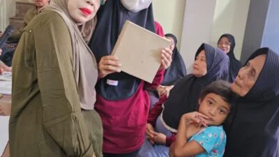 Keterangan Gambar: DR. Anaita K, S.H., M.Kn selaku ketua Senam Lansia Vitalage Movement dan juga selaku Bu RW 06 saat Berikan Parsel