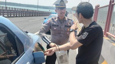 petugas membantu seorang pengendara mobil (R4) yang kehabisan bahan bakar saat melintas di atas Jembatan Tol Suramadu