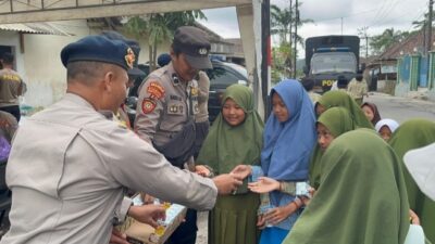 Personel Brimob Polda Jawa Timur (Jatim) bersama Polres Lumajang membagikan snack dan susu kepada anak-anak sekolah di Dusun Sumbersari