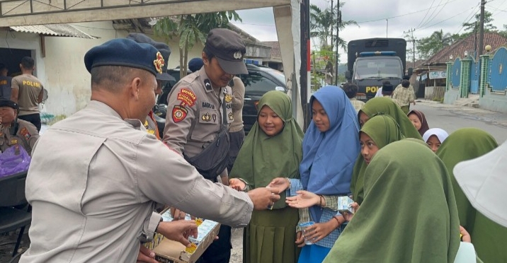 Personel Brimob Polda Jawa Timur (Jatim) bersama Polres Lumajang membagikan snack dan susu kepada anak-anak sekolah di Dusun Sumbersari