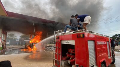 Prajurit Kodaeral XI beserta unit truk Damkar Kodaeral XI dalam rangka memberi pertolongan dan memadamkan kebakaran pada Stasiun Pengisian Bahan Bakar Umum (SPBU)