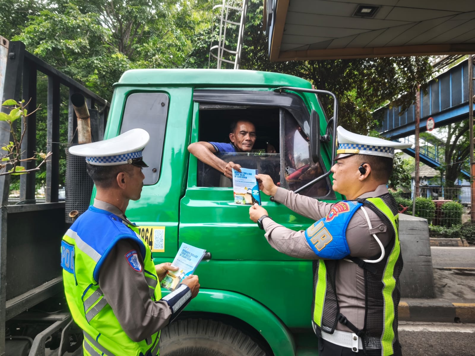 Satuan PJR (Patroli Jalan Raya), Ditlantas Polda Jatim membagikan flyer himbauan penggunaan lajur kepada pengguna jalan khususnya jalan tol.
