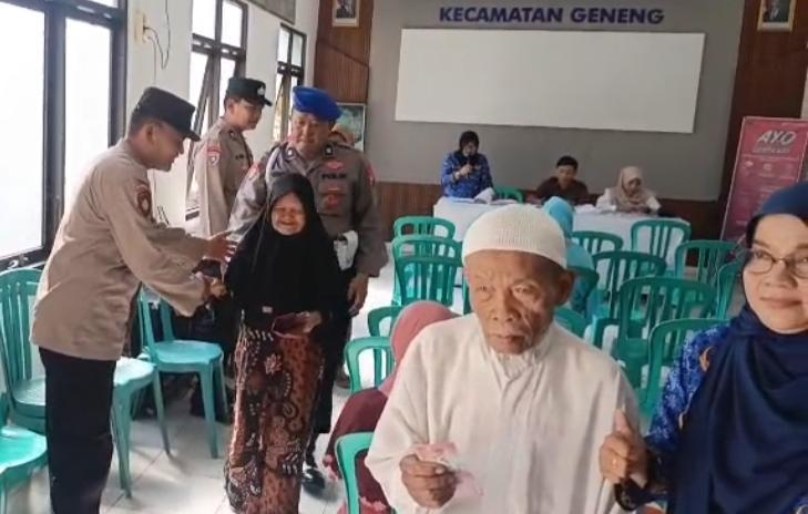 Personel Polsek Geneng Polres Ngawi membantu proses penyaluran Bantuan Sosial Program Keluarga Harapan (PKH )