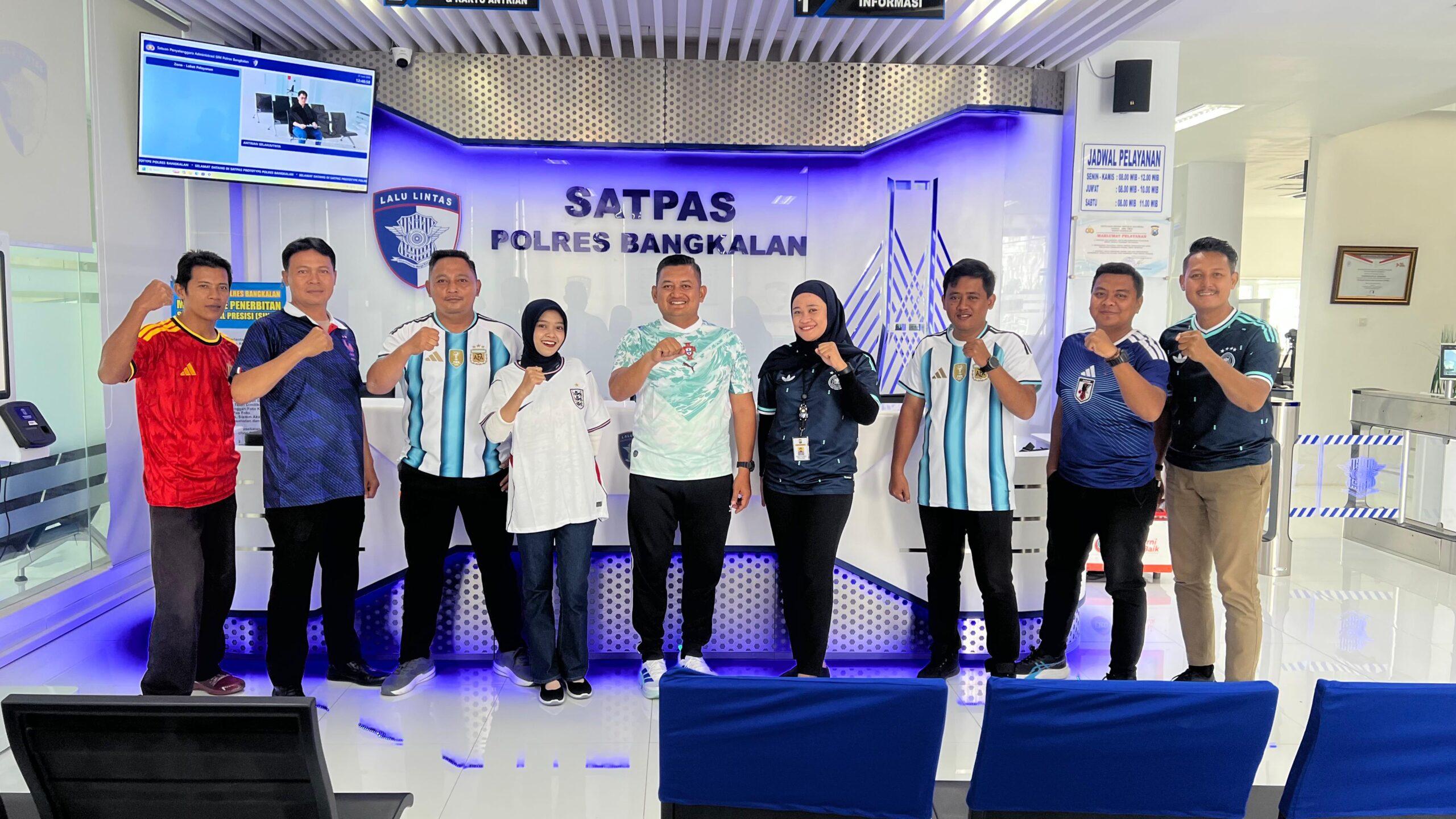 petugas saat mengenakan jersey bertema Piala Dunia saat melayani pemohon