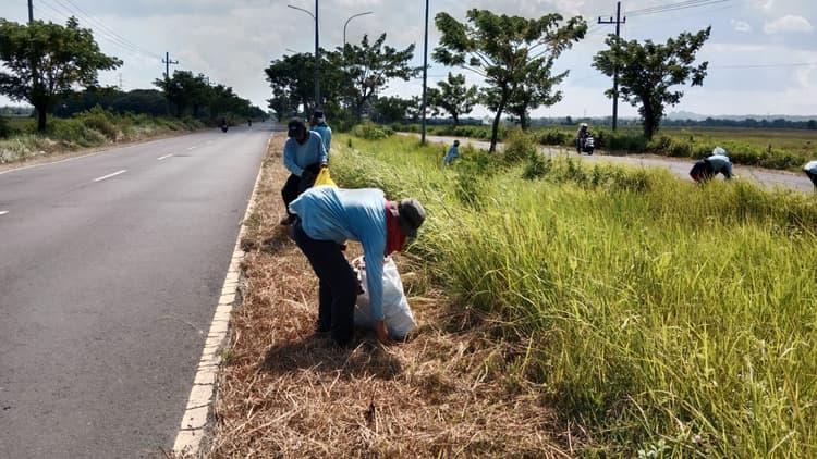 Petugas saat membersihkan sampah di jalan akses jembatan Suramadu