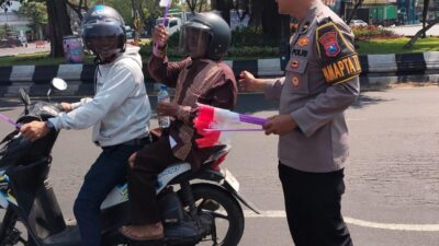 Sambut HUT ke-81 RI, Polres Pelabuhan Tanjung Perak Bagikan Bendera Merah Putih kepada Pengendara