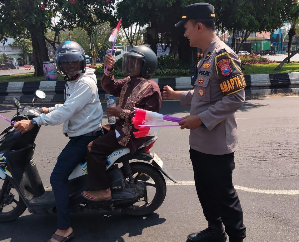 HUT Kemerdekaan Republik Indonesia ke-81 digelorakan Polres Pelabuhan Tanjung Perak membagikan bendera Merah Putih kepada masyarakat